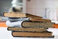 Old books stacked on a white table. Old release without titles. Royalty Free Stock Photo