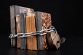 Old books strapping a shiny chain. Forbidden literature locked with a padlock Royalty Free Stock Photo
