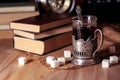 Old books and tea in the evening. A glass of drink on table. The Royalty Free Stock Photo