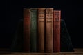 old books on top of one another on a table, against a black background Royalty Free Stock Photo