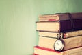 Old books with vintage pocket watch on a wooden table. retro filtered image Royalty Free Stock Photo