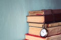 Old books with vintage pocket watch on a wooden table. retro filtered image Royalty Free Stock Photo