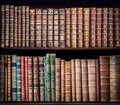 Old books on vintage wooden shelf.