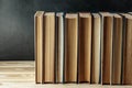 Old books on wooden shelf on dark background. Collection of vintage literature. Education and learning