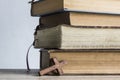 Old books on a wooden table with a wooden cross