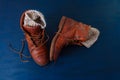 Old boot red brown shoes blue top view background leather laces high canvas dirty wool knitted warm gray socks