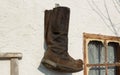 Old boots hang on the wall of a village house Royalty Free Stock Photo