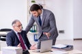 Old boss and his young assistant working in the office Royalty Free Stock Photo