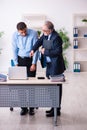 Old boss and his young assistant in the office Royalty Free Stock Photo