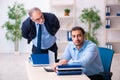 Old boss and his young assistant in the office Royalty Free Stock Photo