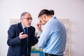 Old boss and his young assistant in the office Royalty Free Stock Photo