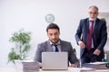 Old boss and his young assistant working in the office Royalty Free Stock Photo