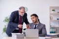 Old boss and his young assistant working in the office Royalty Free Stock Photo