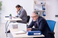 Old boss and his young assistant working in the office Royalty Free Stock Photo