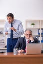 Old boss and young male employee in the office Royalty Free Stock Photo