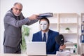 Old boss and young male employee wearing masks