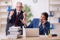 Old boss and young male employee working in the office