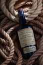 Old bottle of whiskey lying on the ropes below the ship