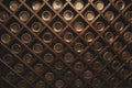 Old bottles of wine on the wall of dark wine cellar. Close-up. Background, pattern, texture. Abstract, design.