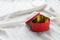 Old box in heart shape on white background, on white cloth, in box red sweet jelly beans, Valentine`s day, women`s day, gifts