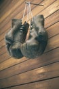 Old boxing gloves hang on nail on wooden wall with copy space for text. High resolution 3d render Royalty Free Stock Photo