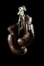 Old Boxing Gloves, hanging, on black Background Royalty Free Stock Photo