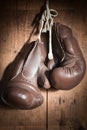 Old Boxing Gloves, hanging on wooden wall Royalty Free Stock Photo