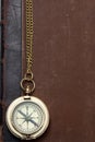 Old brass compass on the vintage book