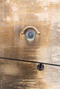 Old brass doorbell button on a beige stone wall