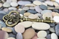 Old Brass key on a pebble beach Royalty Free Stock Photo