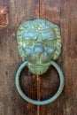 Old brazen lion head door knocker on a wooden door Royalty Free Stock Photo