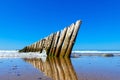Old breakwater and its reflection in the wet sand. Royalty Free Stock Photo