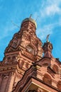 Old brick bell tower of the Orthodox Church against the blue sky