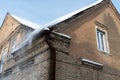 Old brick building covered in snow of heavy snowfall. Hanging icicles from the roof of a residential building. View of the red Royalty Free Stock Photo