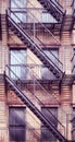 Old brick building with iron fire escape, color toning applied, New York City, USA