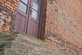 Old brick building with stone steps and wooden glass doors