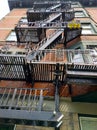 Old brick building with three yellow flower ports on fire escape stairs. Vancouver, BC, Canada. Royalty Free Stock Photo