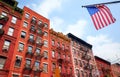 Old brick buildings with fire escapes and American Flag, New York City, USA Royalty Free Stock Photo