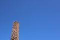 Old industrial square chimney against deep blue background with copyspace