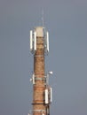 Old brick chimney covered with many antennas and other modern technology