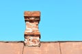 An old brick chimney on a house with an iron roof Royalty Free Stock Photo