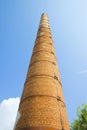 Old brick chimney isolated on sky with metal reinforcements Royalty Free Stock Photo