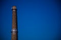 Old brick factory pipe with smoke-free antennas GSM on blue sky background. Concept pollution of environment, emissions into water Royalty Free Stock Photo