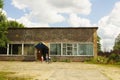 Old brick food store with porch and sign in Russian - SHOP beside the road.