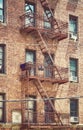 Old brick house building with iron fire escape, color toned picture, New York City, USA