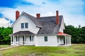 Old brick house in traditional American style. The beautiful white building has two verandas. Summer day, blue sky