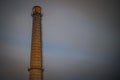 Old brick industrial chimney in the dark. A chimney of the Soviet era Royalty Free Stock Photo