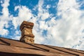 An old brick pipe on the roof of a residential building with an iron roof against a background of clouds, HDR Royalty Free Stock Photo