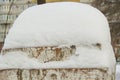 On an old brick post with cracked plaster lies a large snowdrift, a winter background with a copy of the space Royalty Free Stock Photo