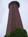 Old brick smokestack with ladder and stork nest